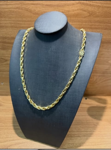 Corrente dourada de elos trabalhados em busto de exposição preto